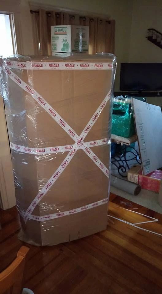 Whitaker Moving LLC team wrapping appliance for a move
